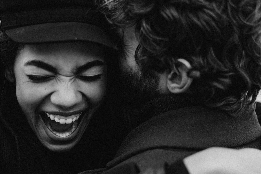 Gray Scale Photo of Smiling Woman hugging a man
