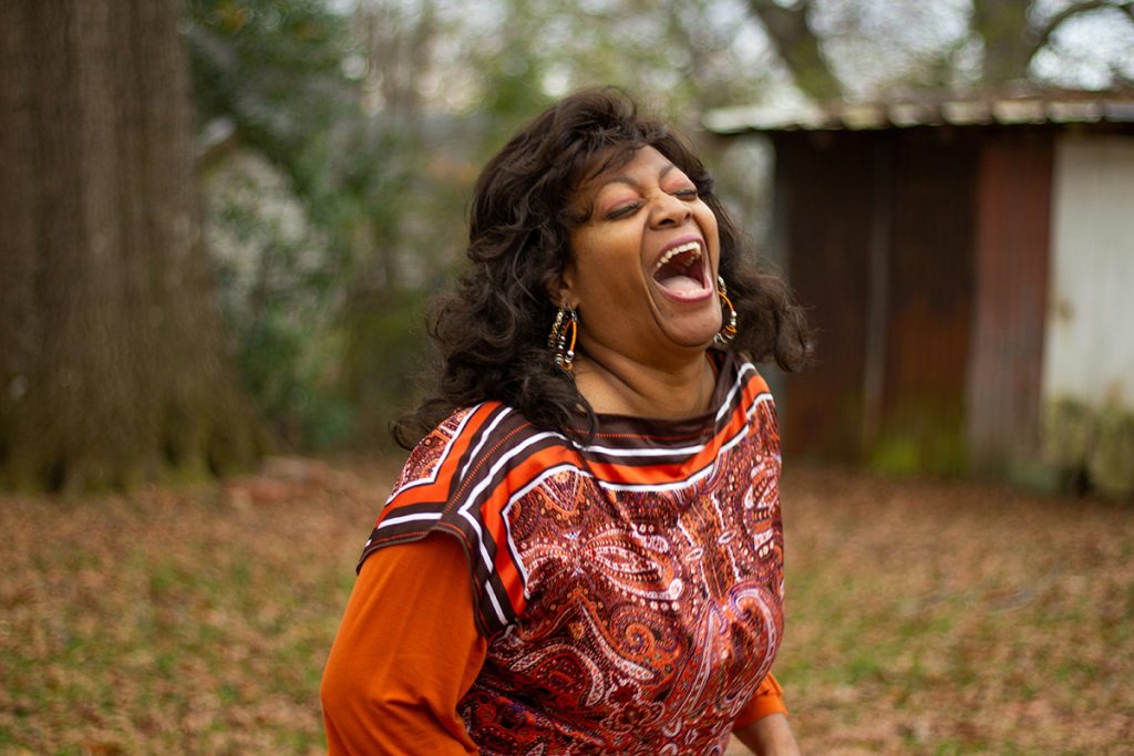 portrait of a beautiful older woman laughing while standing outdoors