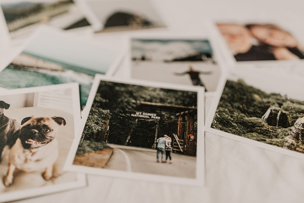 assortment of printed photos on a white table